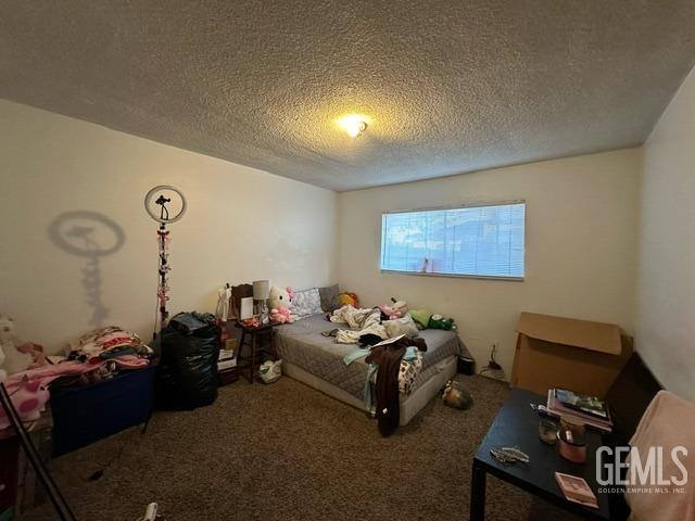 bedroom featuring carpet flooring and a textured ceiling