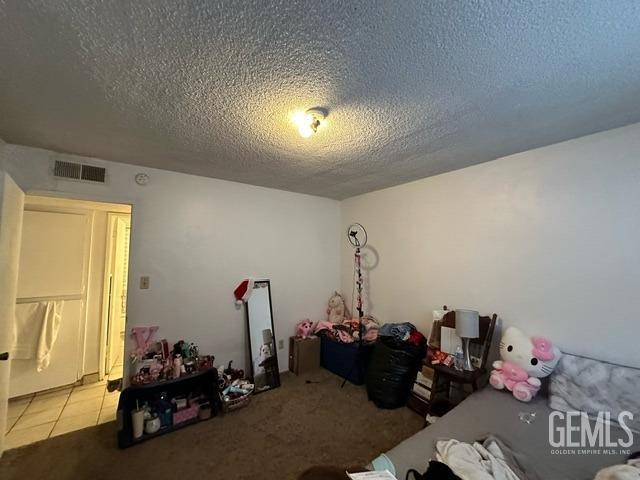 bedroom with carpet floors and a textured ceiling