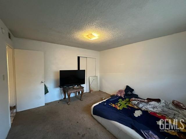 carpeted bedroom featuring a textured ceiling