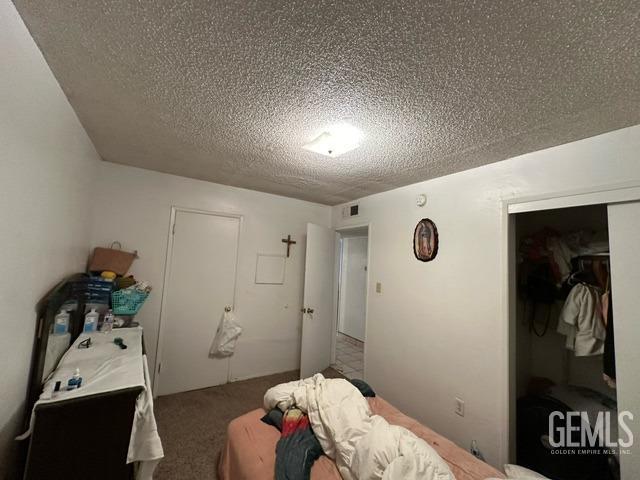 unfurnished bedroom with a textured ceiling and a closet