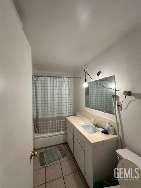 full bathroom featuring tile patterned flooring, vanity, shower / bath combo, and toilet