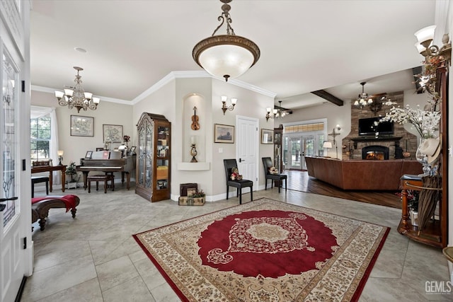 interior space with a fireplace, a chandelier, french doors, and ornamental molding