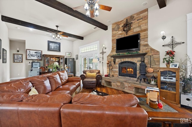 living room with beam ceiling, ceiling fan, french doors, a stone fireplace, and hardwood / wood-style flooring