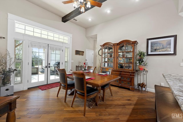 dining area featuring french doors, a towering ceiling, ceiling fan, beam ceiling, and dark hardwood / wood-style floors