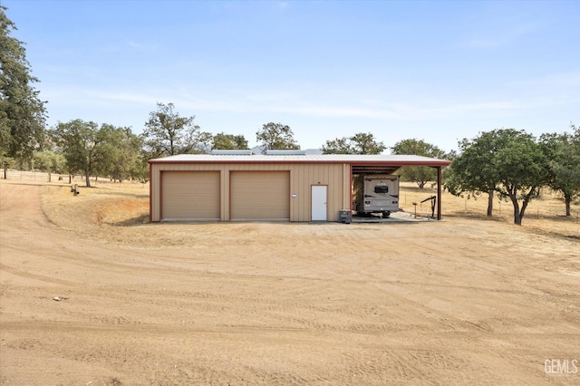 garage featuring a carport and a rural view