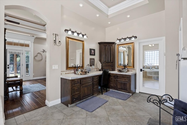 bathroom featuring a raised ceiling, crown molding, tile patterned floors, and vanity