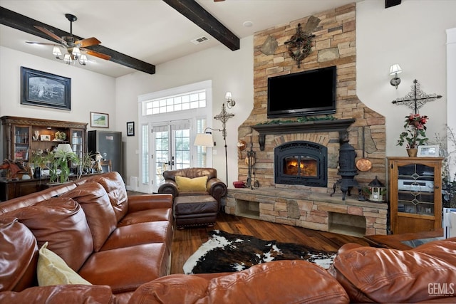 living room with french doors, ceiling fan, beam ceiling, hardwood / wood-style flooring, and a fireplace