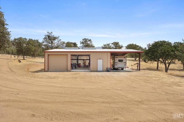 garage featuring a rural view and a carport