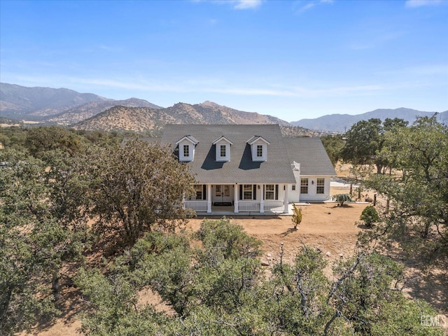 back of house with a mountain view and a porch