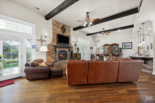 living room featuring ceiling fan, a fireplace, beamed ceiling, and dark wood-type flooring