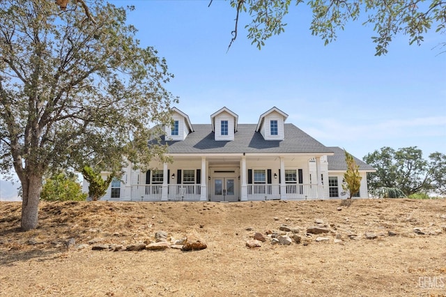 cape cod house featuring covered porch and french doors