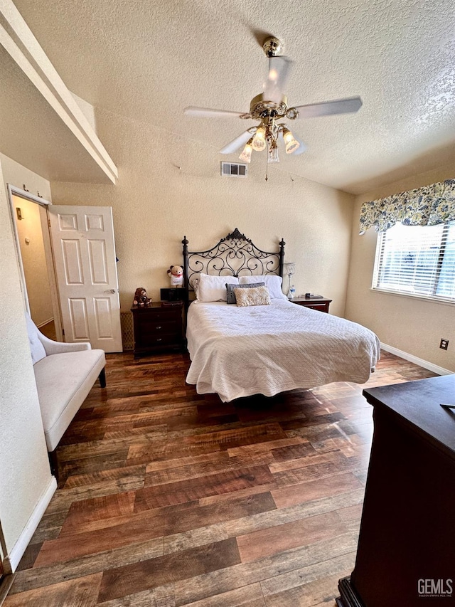 bedroom with dark wood-type flooring, ceiling fan, and a textured ceiling