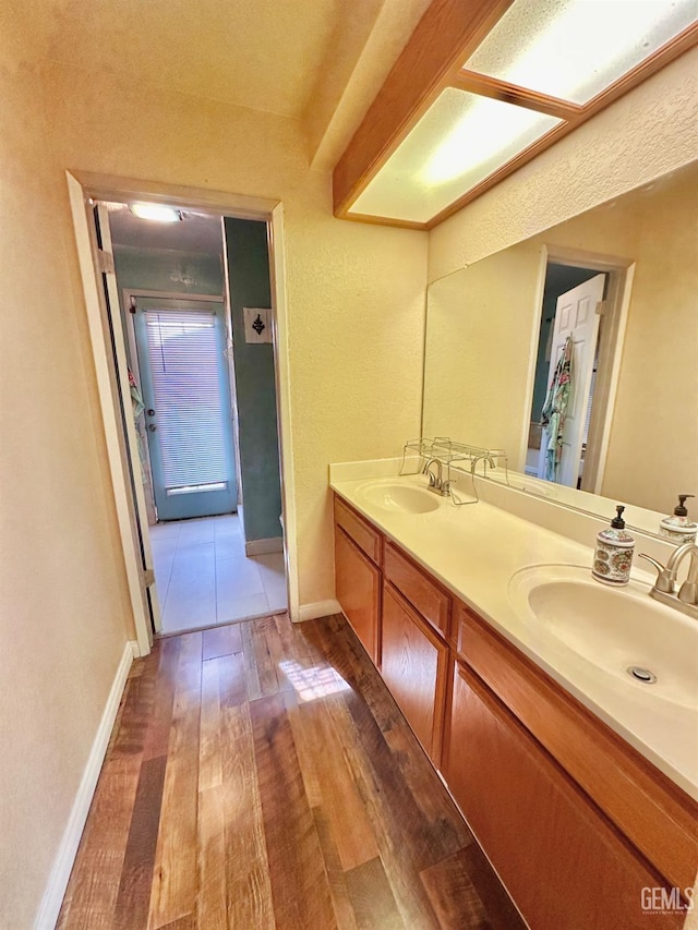 bathroom featuring vanity, hardwood / wood-style floors, and a skylight