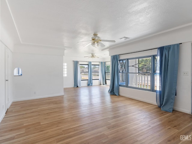 spare room featuring a textured ceiling, light wood-type flooring, and ceiling fan