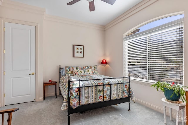 carpeted bedroom featuring ceiling fan and crown molding