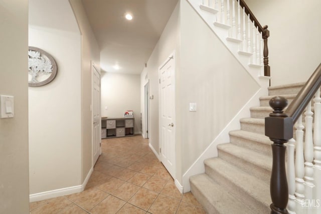 interior space featuring light tile patterned floors, recessed lighting, stairs, and baseboards