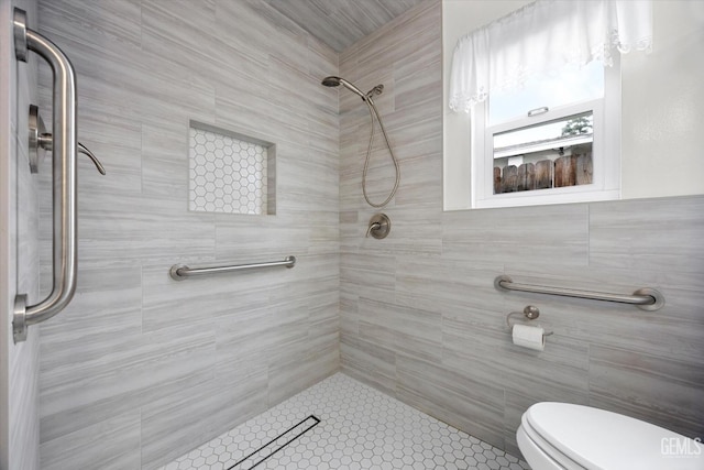 bathroom featuring tiled shower and toilet