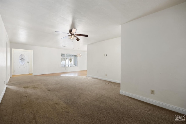 unfurnished room with ceiling fan with notable chandelier and carpet flooring