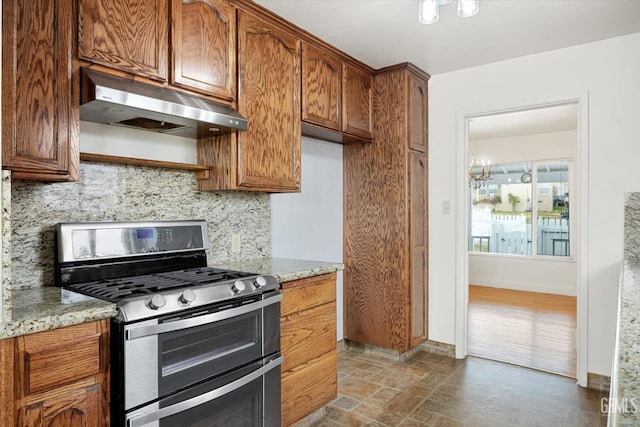 kitchen with range with two ovens, light stone countertops, and decorative backsplash