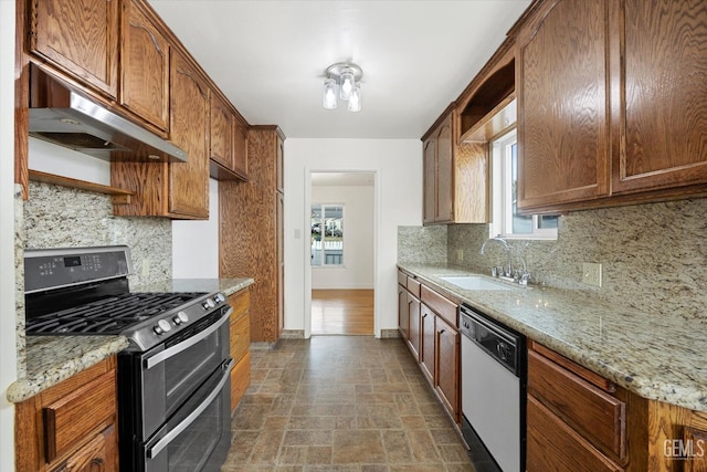 kitchen featuring light stone counters, sink, decorative backsplash, and appliances with stainless steel finishes