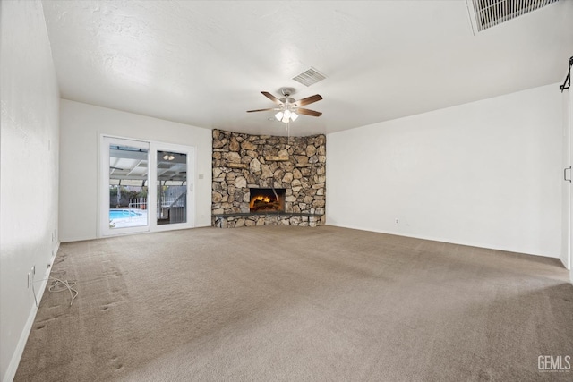 unfurnished living room featuring ceiling fan, a fireplace, and carpet flooring