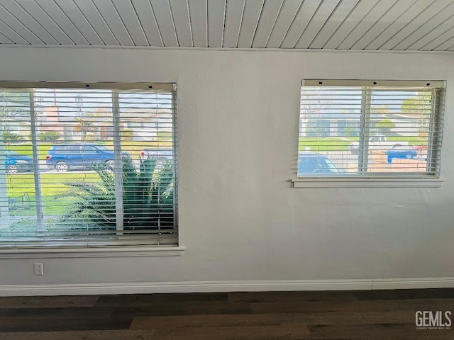 unfurnished room featuring dark wood-style flooring and baseboards