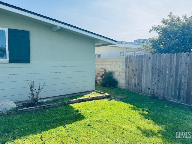 view of home's exterior featuring stucco siding, a yard, and fence