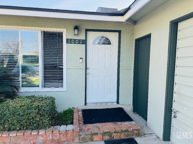 entrance to property featuring stucco siding