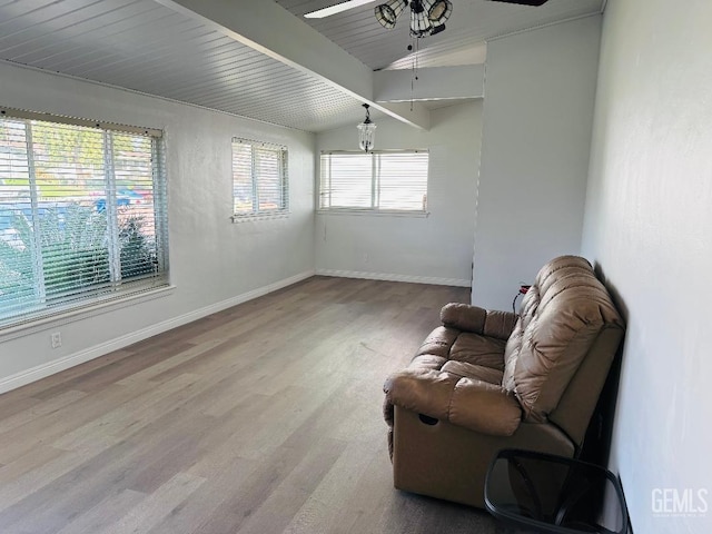 sitting room featuring baseboards, lofted ceiling with beams, wooden ceiling, ceiling fan, and light wood-style floors