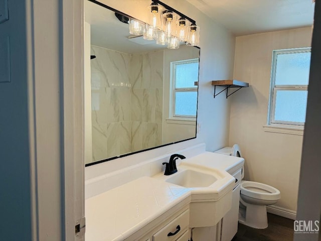 full bathroom with baseboards, vanity, toilet, and walk in shower