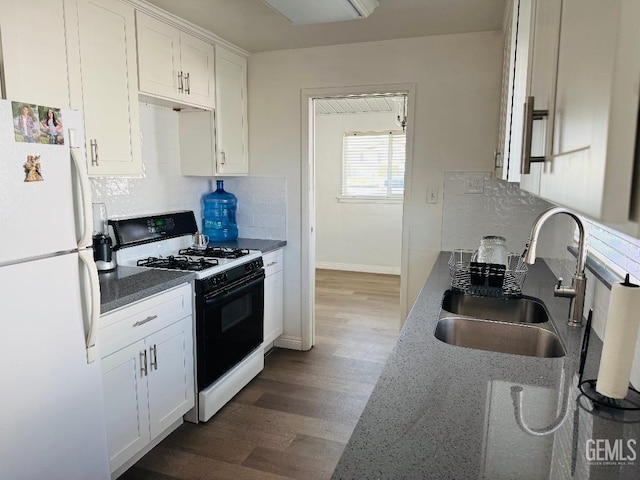 kitchen featuring backsplash, freestanding refrigerator, gas stove, white cabinets, and a sink