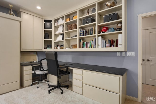 carpeted office space with built in desk