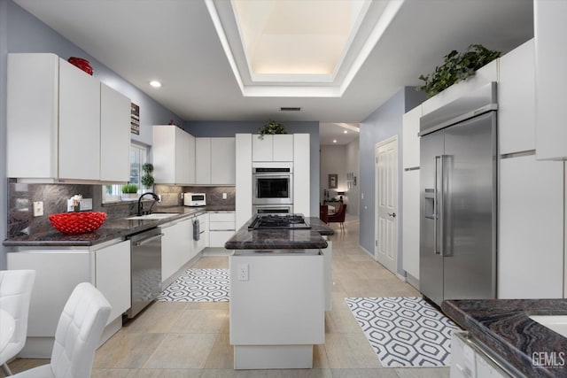 kitchen featuring a center island, white cabinetry, sink, and appliances with stainless steel finishes