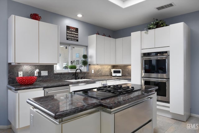 kitchen featuring sink, a center island, light tile patterned floors, white cabinets, and appliances with stainless steel finishes