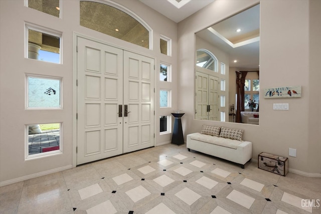 foyer entrance featuring light tile patterned floors and a high ceiling