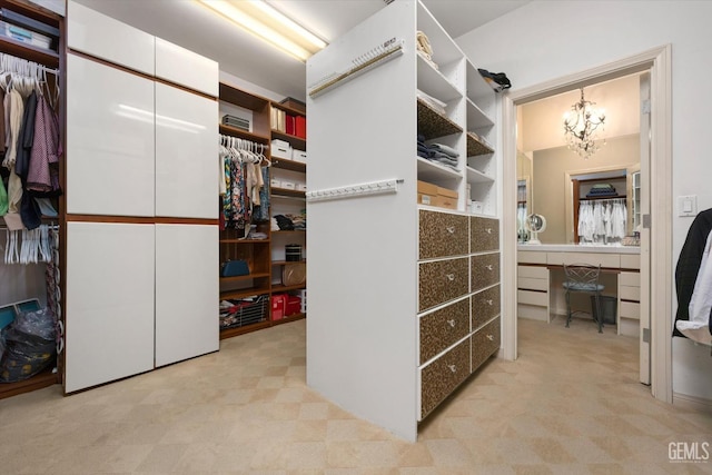 spacious closet featuring an inviting chandelier