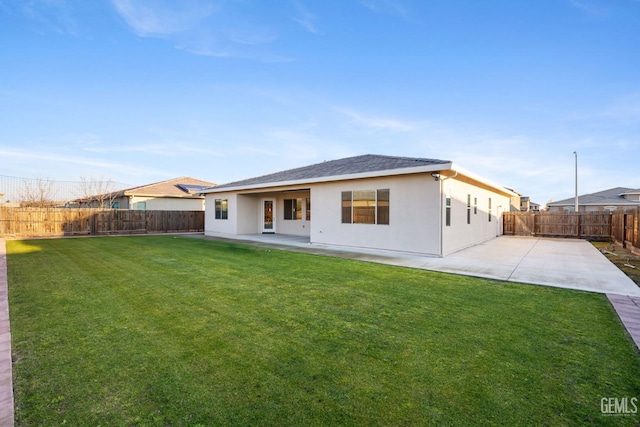 back of property with a lawn and a patio area