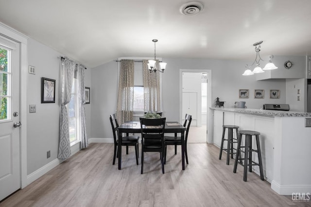 dining area with light wood-type flooring, baseboards, visible vents, and a chandelier