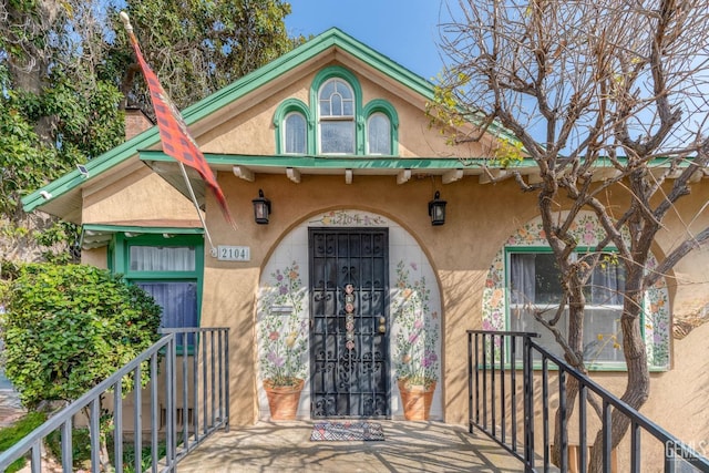 doorway to property featuring stucco siding