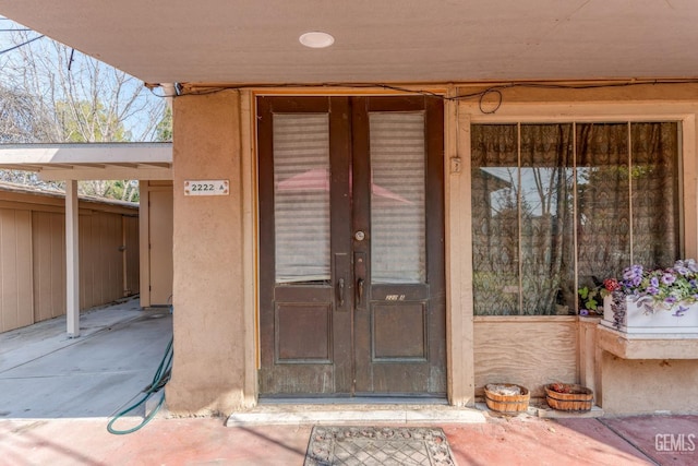 property entrance featuring stucco siding and french doors