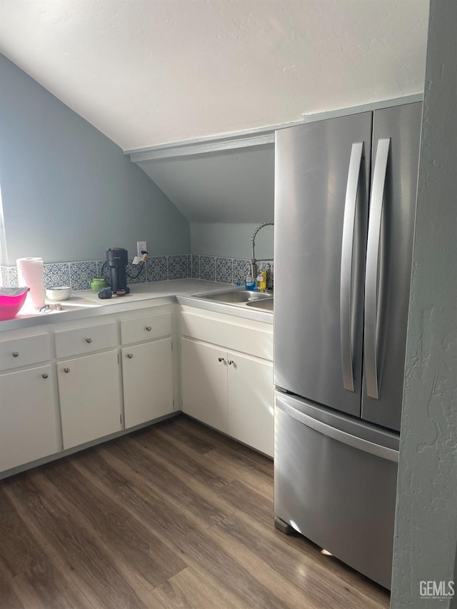 kitchen with white cabinets, dark wood-type flooring, freestanding refrigerator, light countertops, and a sink