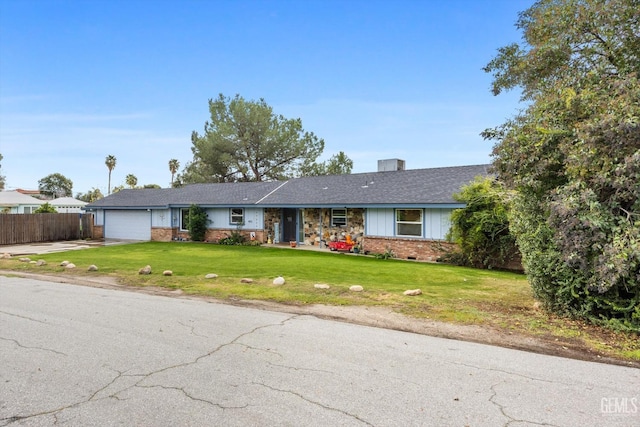 ranch-style home featuring a garage, brick siding, fence, driveway, and a front lawn