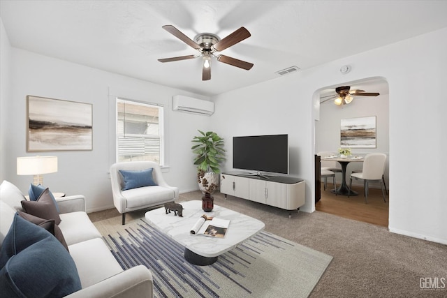 carpeted living room with ceiling fan and a wall mounted air conditioner