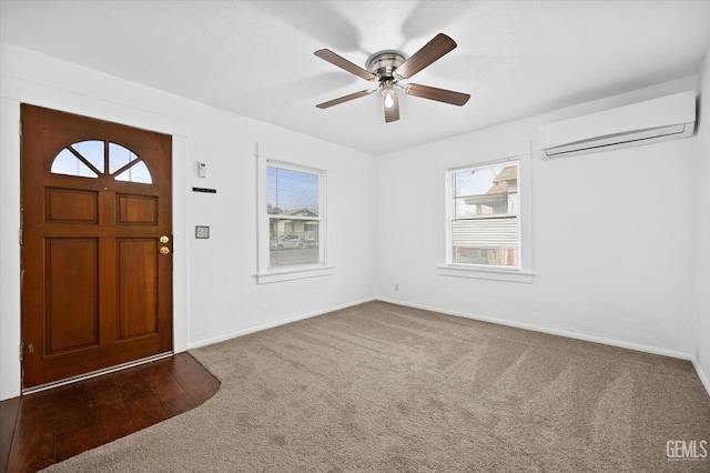 carpeted entryway with ceiling fan, a healthy amount of sunlight, and a wall unit AC