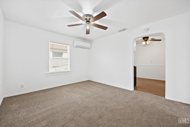 carpeted empty room featuring a wall mounted air conditioner and ceiling fan