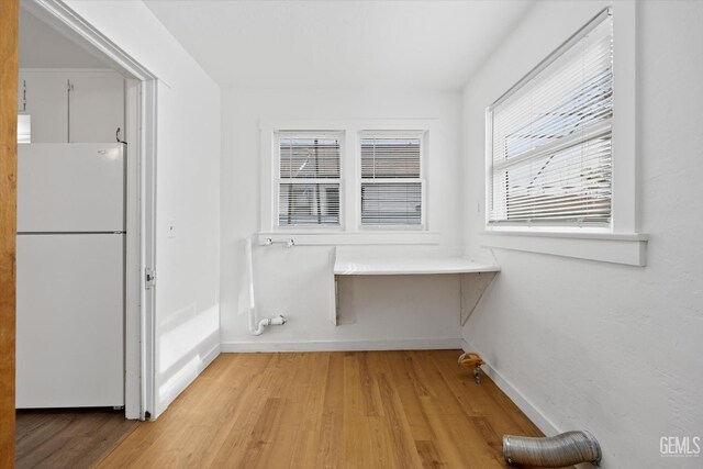 clothes washing area featuring light hardwood / wood-style floors