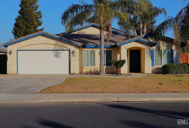 ranch-style house featuring a garage and a front lawn