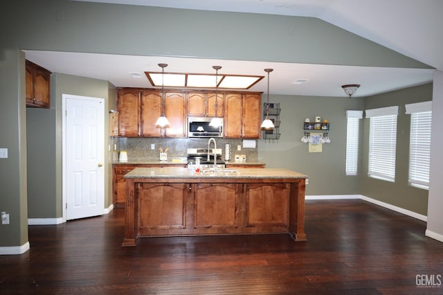 kitchen featuring lofted ceiling, appliances with stainless steel finishes, hanging light fixtures, dark hardwood / wood-style floors, and tasteful backsplash