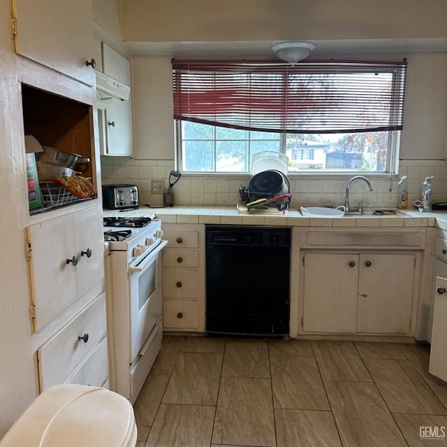 kitchen with tile countertops, gas range gas stove, sink, and black dishwasher