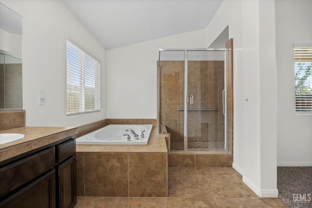 bathroom featuring vanity, vaulted ceiling, a garden tub, and a stall shower